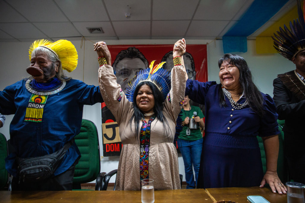From left: Chief Raoni Metuktire, Sonia Guajajara and Joenia Wapichana raise their hands together to celebrate Brazilian Indigenous communities taking over the Funai (National Foundation of the Indigenous People), on January 2 / credit: Antonio Cascio